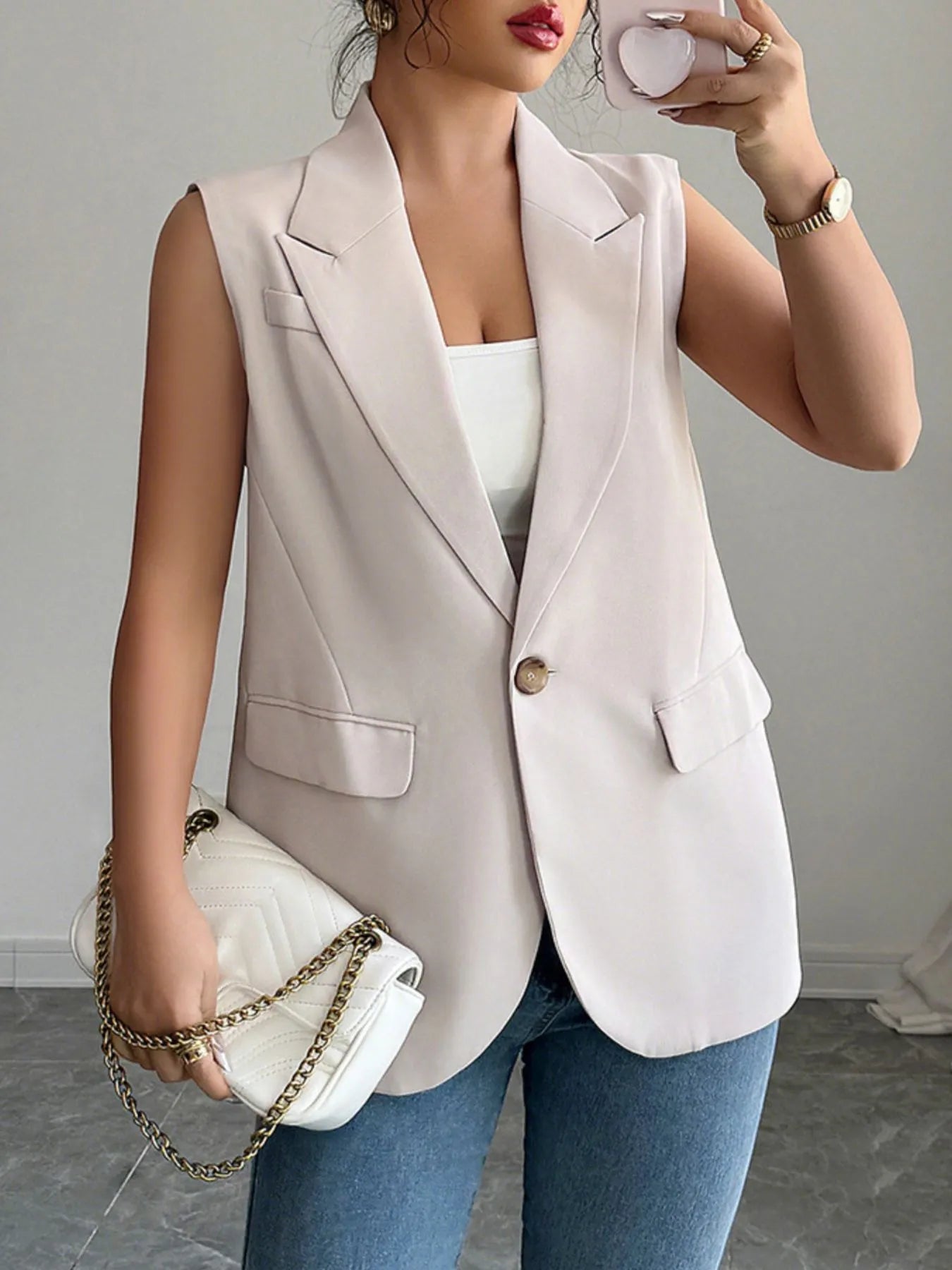 One Button Sleeveless Blazer in light pink, paired with a white top and handbag for a chic, modern look.
