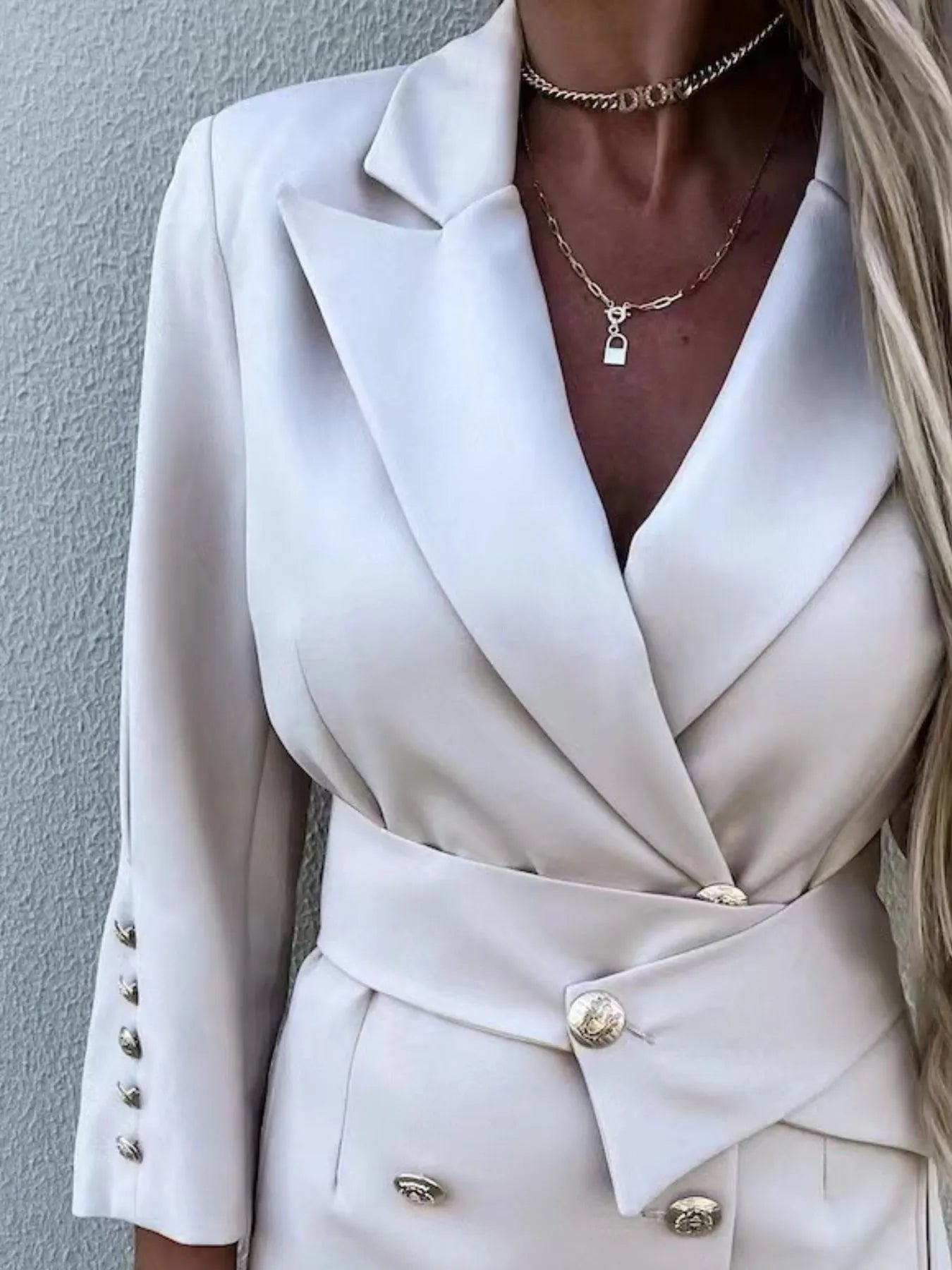 Close-up of a woman wearing a Double-Breasted Lapel Collar Longline Blazer in white, showcasing its elegant design and buttons.